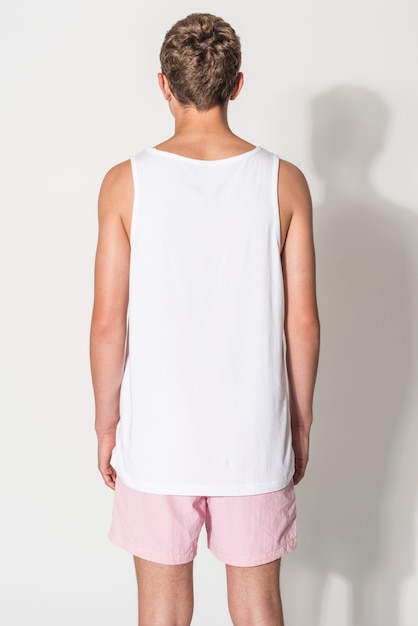 Free photo men’s white tank top and pink shorts for teen’s summer apparel shoot with design space