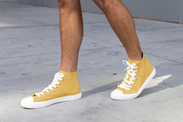 Free photo men's ankle sneakers yellow street style apparel shoot