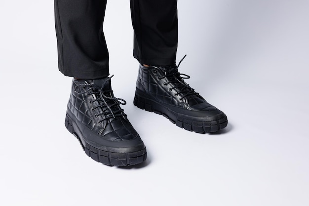 가죽으로 만든 남성용 검은색 부츠, 흰색 바탕에 남성용 신발. 겨울 남성 신발 2022 프리미엄 사진