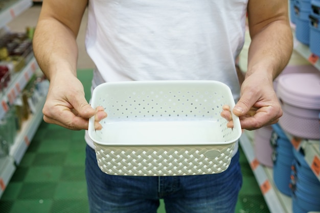 Men's hands hold a plastic box basket