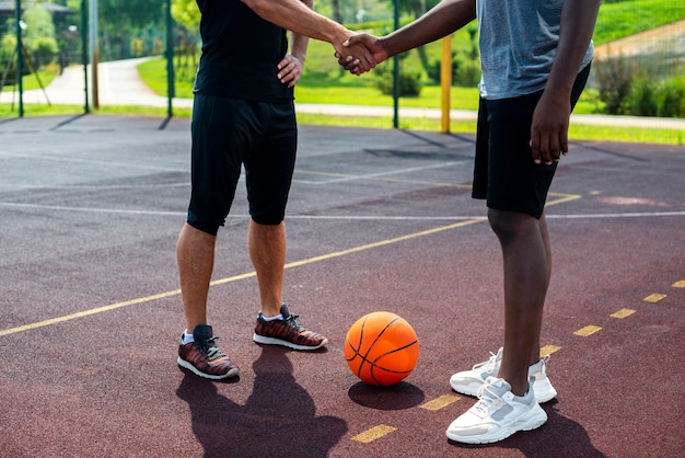バスケットボールコートで握手する男性