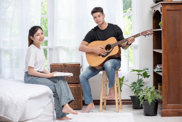 Men sitting guitar and women holding books and singing.