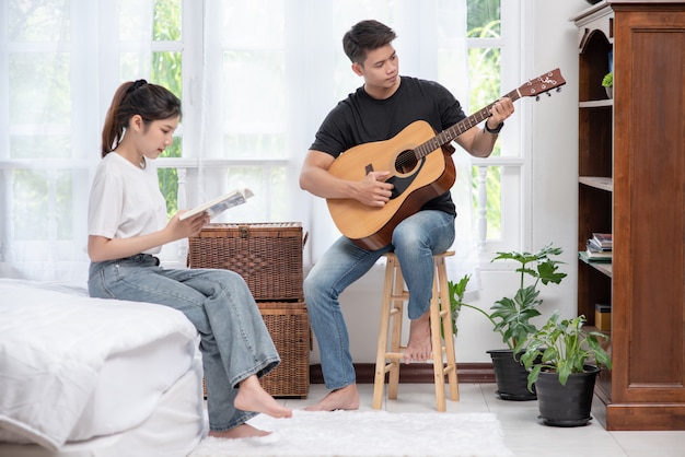 기타와 여자 책을 들고 노래를 앉아 남자.