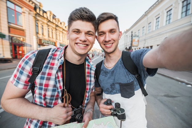 Free photo men taking selfie on street