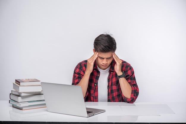Men use laptops in the office and are stressed.