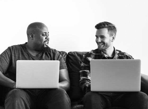 Free photo men using laptop sitting on sofa