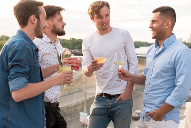Бесплатное фото Мужчины с напитками на вечеринке