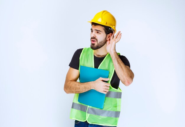 Men with helmet opening ear to hear well.