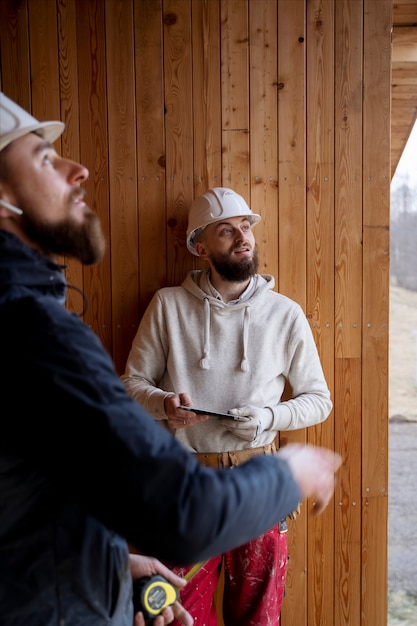 Foto gratuita uomini con i caschi che lavorano insieme