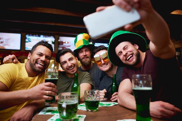 聖パトリックの日を祝うレプラコーンの帽子とビールを持つ男性