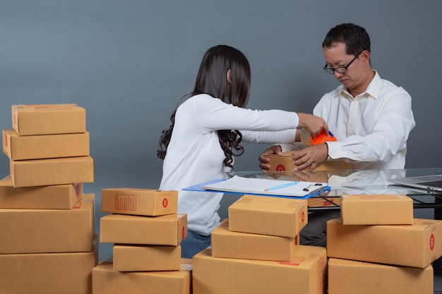 Men and women are helping to pack the boxes.