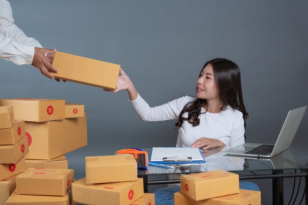 Men and women are helping to pack the boxes.