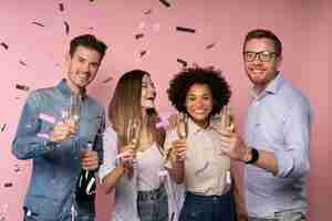 Free photo men and women celebration with champagne glasses and confetti