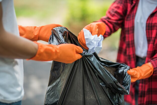 Men and women help each other to collect garbage.