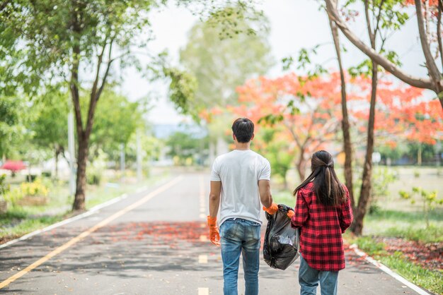 Men and women help each other to collect garbage.