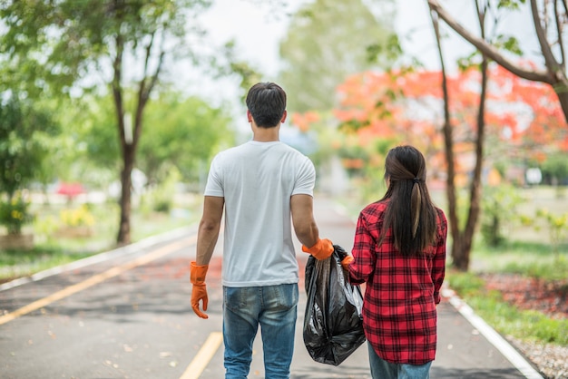 Men and women help each other to collect garbage.