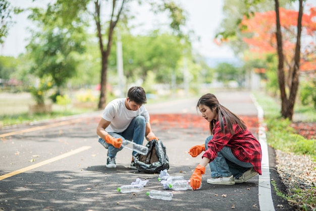 Men and women help each other to collect garbage.