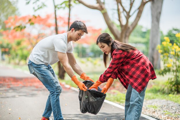 Men and women help each other to collect garbage.