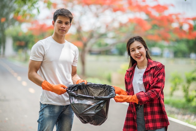 Men and women help each other to collect garbage.