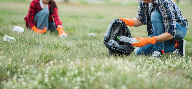 Men and women help each other to collect garbage.