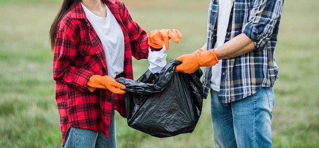 Men and women help each other to collect garbage.