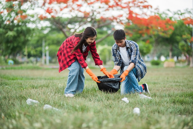 Men and women help each other to collect garbage.