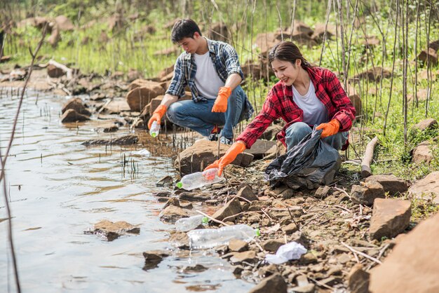 Men and women help each other to collect garbage.