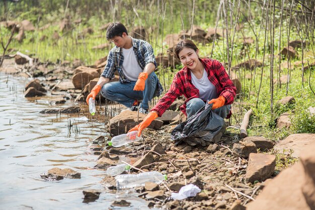 Men and women help each other to collect garbage.