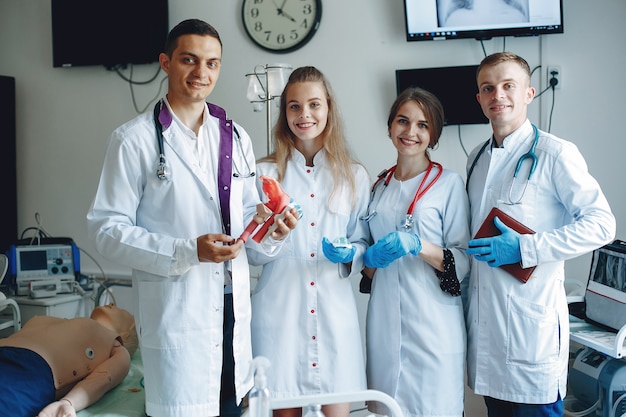 Foto gratuita uomini e donne in camici da ospedale tengono in mano attrezzature mediche