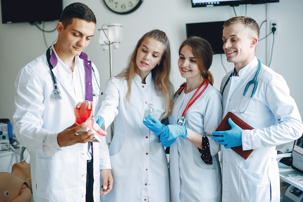 Men and women in hospital gowns hold medical equipment in their hands