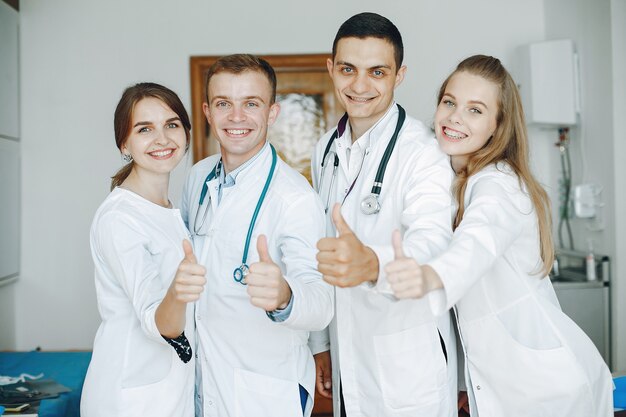 Men and women in hospital gowns hold medical equipment in their hands