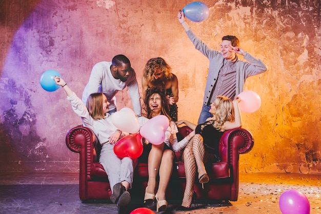 Men and women playing with balloons