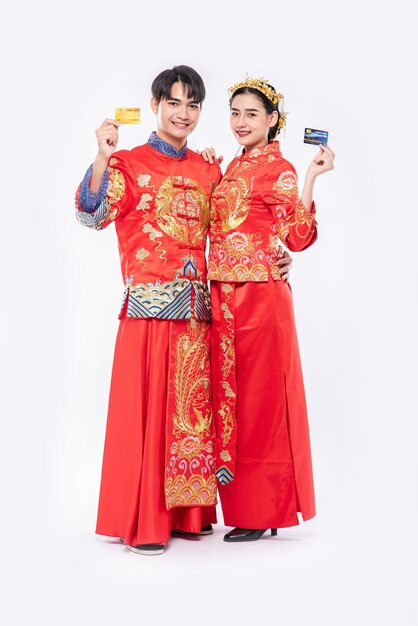 Men and women wearing qipao go shopping with credit cards.