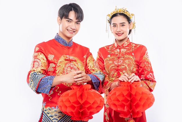 Men and women wearing qipao standing with Honeycomb lamp, Isolated on white background.