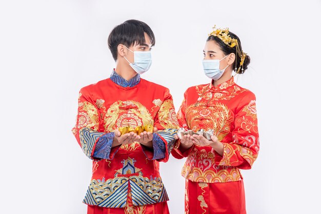 Men and women wearing Qipao and wearing masks Spend with gold money