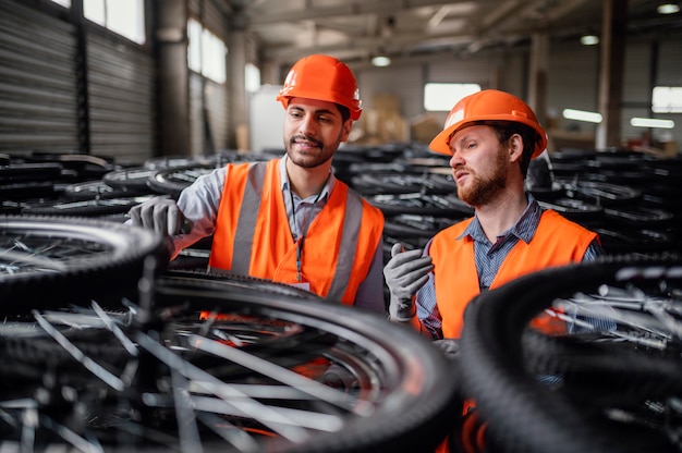 Free photo men working next to a bunch of wheels