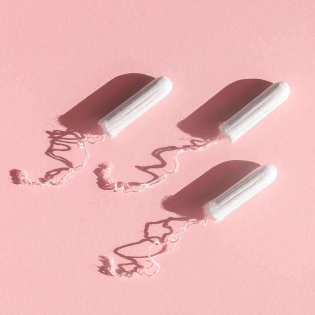 Menstrual tampons with thread on pink background