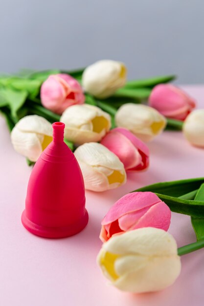 Menstruation cup beside tulips