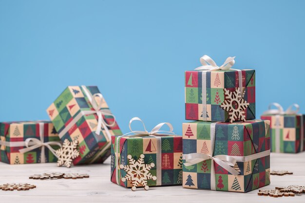 С рождеством. подарки в коробках в праздничной бумаге, деревянные снежинки на зиму.