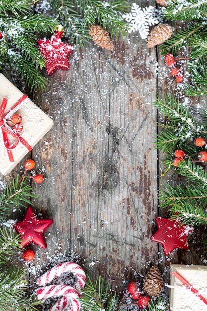 メリークリスマスとハッピーホリデーのグリーティングカード、フレーム、バナー。新年。木製の背景に雪と年賀状。冬のクリスマスの休日のテーマ。フラットレイ。コピースペース