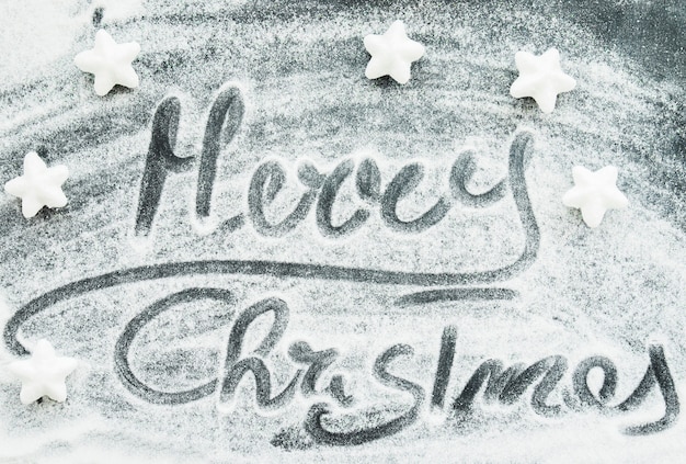 Free Photo merry christmas inscription between decorative snow and stars 