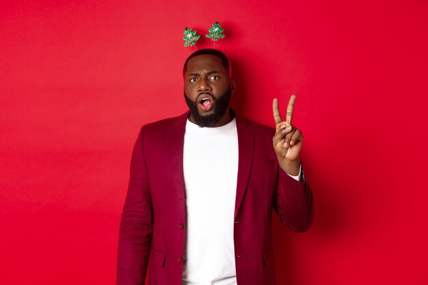 Merry Christmas. Masculine black man in costume and silly party headband