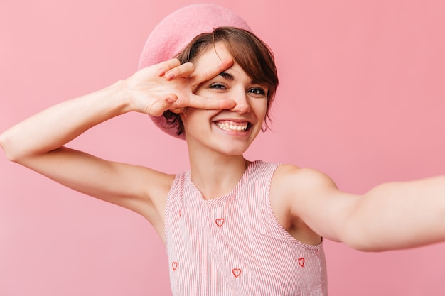 Foto gratuita donna francese allegra che mostra il segno di pace