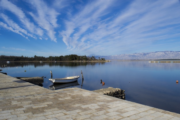 無料写真 雲の流れと青い空の下で大きな湖の魅惑的なパノラマショット