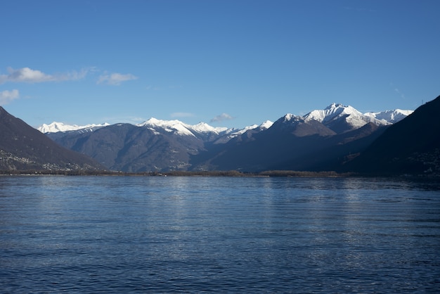 Завораживающая фотография озера на фоне огромных гор днем