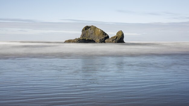 Mesmerizing shot of a huge rock with ocean