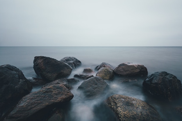 독일 Ostsee의 흐린 하늘 아래 바위 해변의 매혹적인 샷