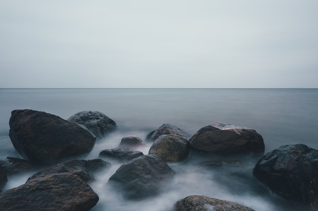 Free photo mesmerizing shot of a rocky seashore under a cloudy sky in ostsee, germany