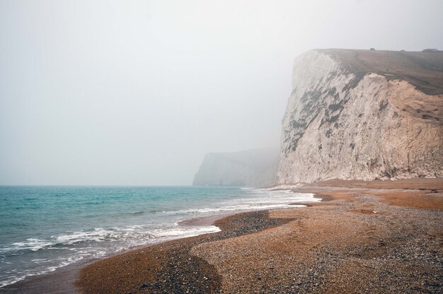Mesmerizing view of the calm ocean on a foggy day in Purbeck Heritage Coast Swanage UK