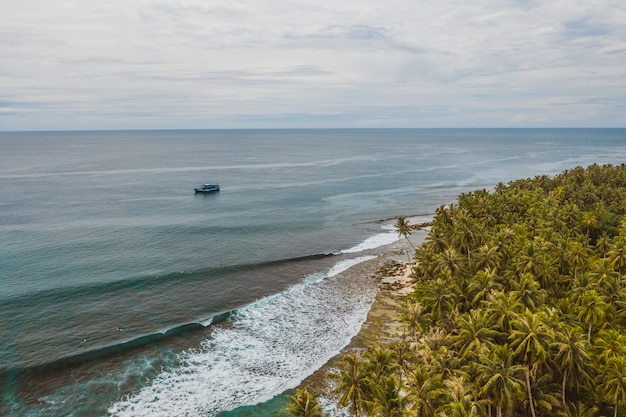 インドネシアの白い砂浜とターコイズブルーの澄んだ水で魅惑的な海岸線の景色